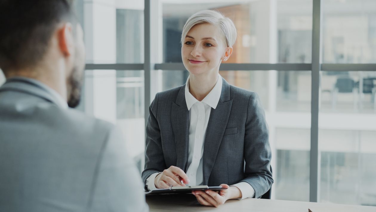 Hiring manager interviewing a candidate in a modern office.