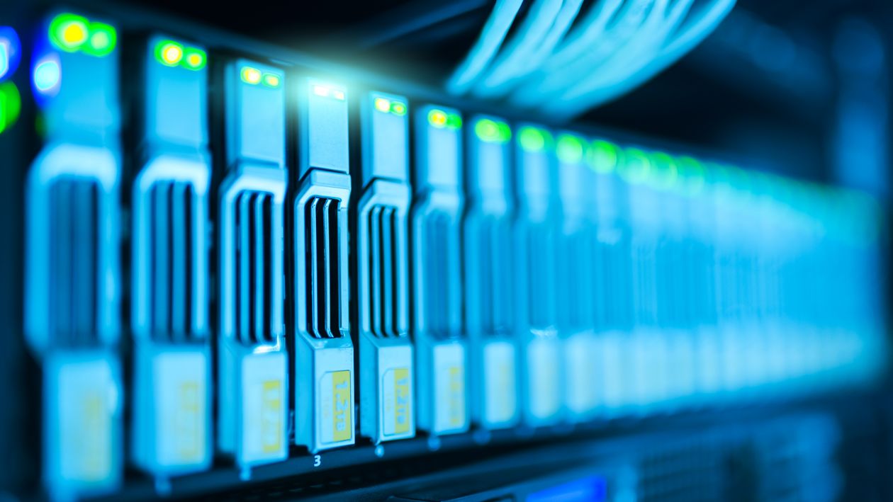 Rows of server racks with glowing indicator lights in a modern data center.